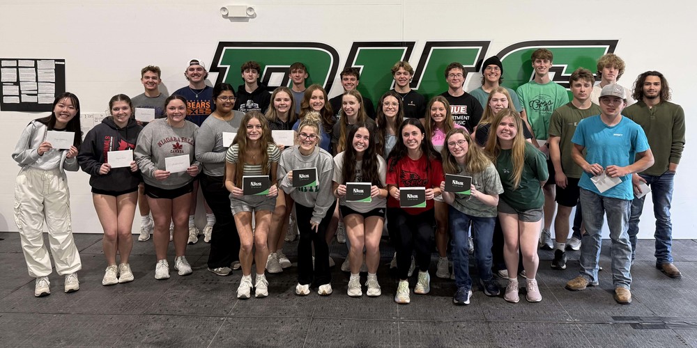 A group photo of 29 PHS graduating seniors who were recognized during the Honor Banquet. Several of them are holding paper invitations from the Bank of Missouri. 