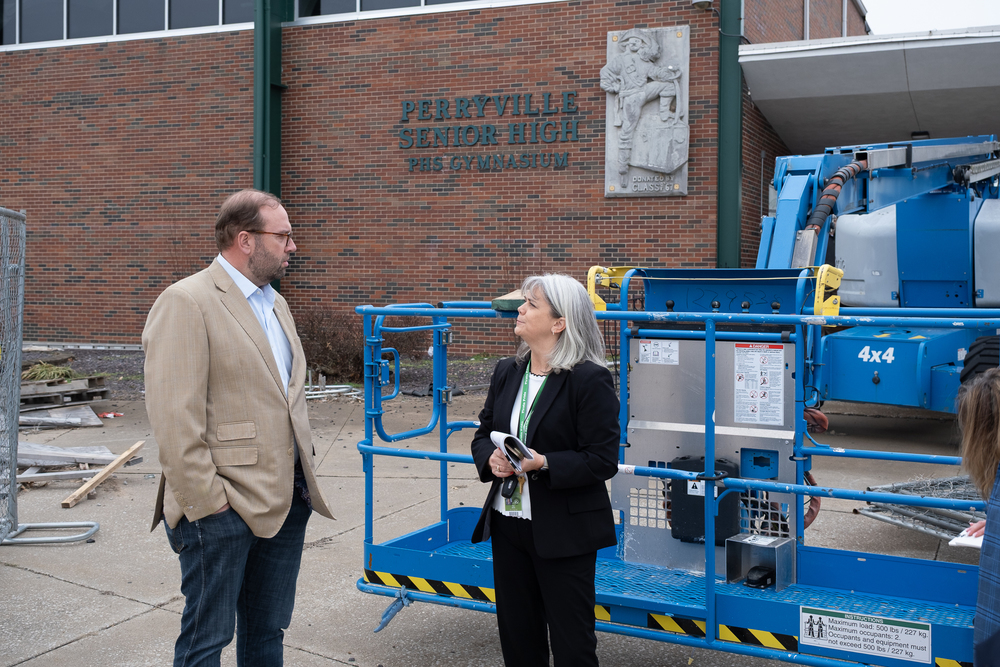 Rep. Jason Smith speaks with Dr. Fara Jones in front of the damaged Perryville High School building.