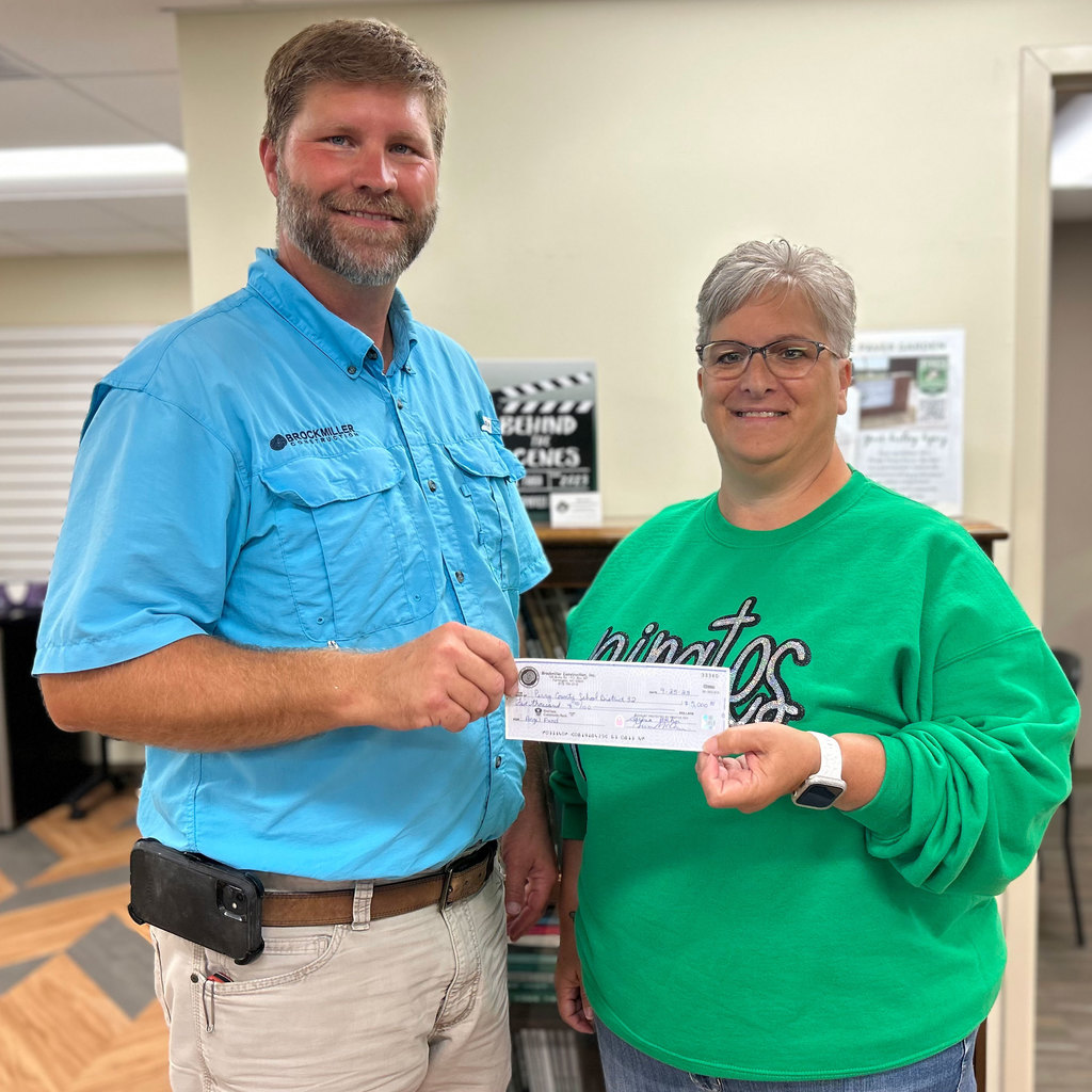 Matt Pigg of Brockmiller Construction presents a check for $5,000 to District 32 Director of Food Services Debbie Baer to support the Angel Fund.