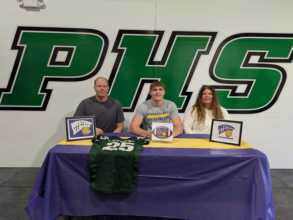 Drew Leuckel is pictured with his dad Brad Leuckel and his mom Kelly Staggs. They are sitting at table with a purple and gold table cloth. Drew's football jersey is draped over the table and he is signing his Letter of Intent. There are also Western Illinois University signs on the table. 