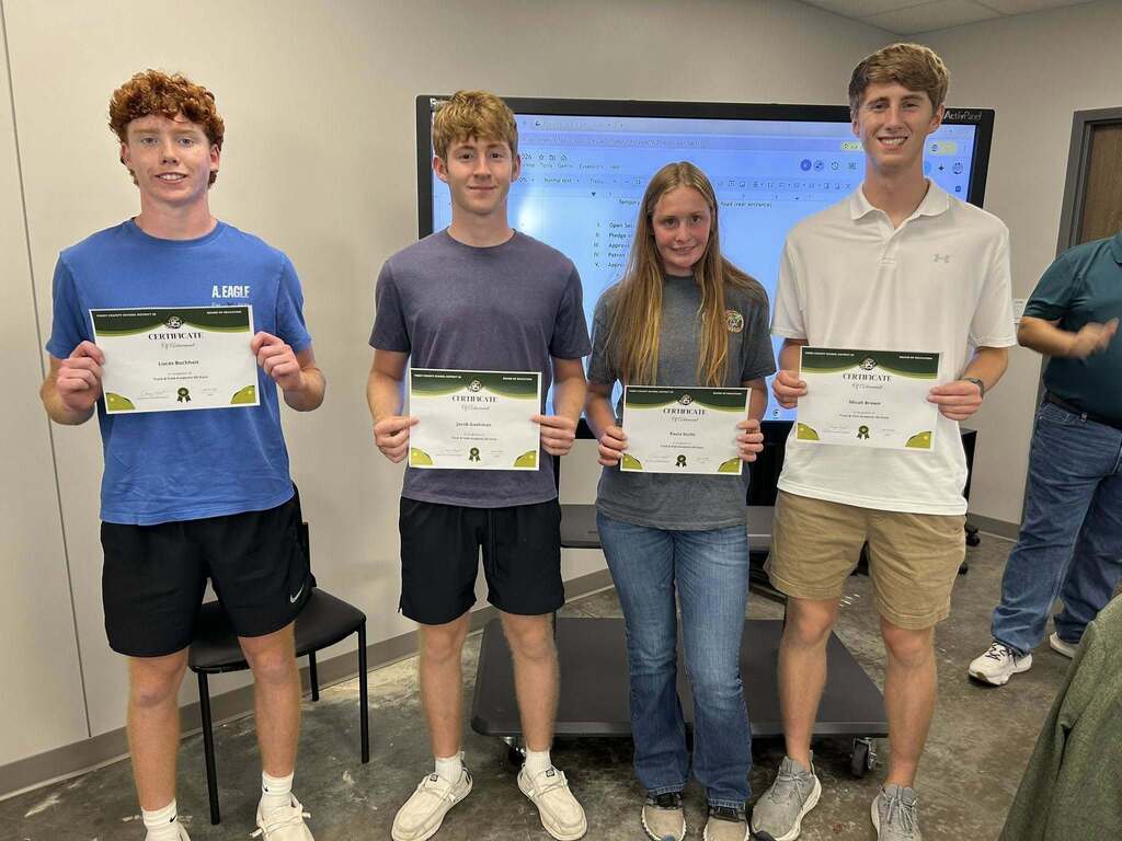 Lucas Buccheit, Jacob Goehman, Paula Sticht, and Micah Brown stand holding certificates