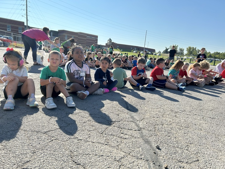 A line of children sitting during a fire drill.