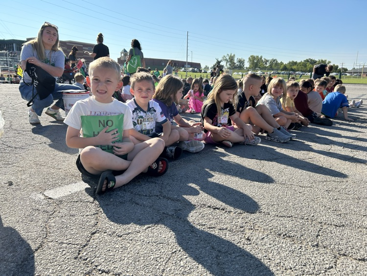 A line of children sitting during a fire drill.