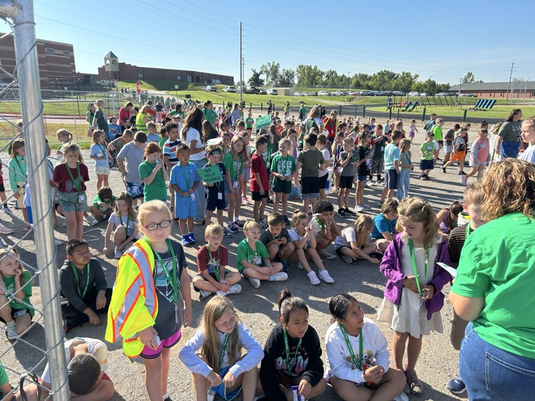 a crowd of children and teachers waiting during a fire drill.