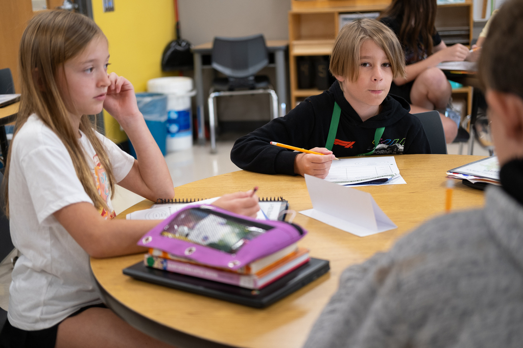 A student looks up from a worksheet he is working on.