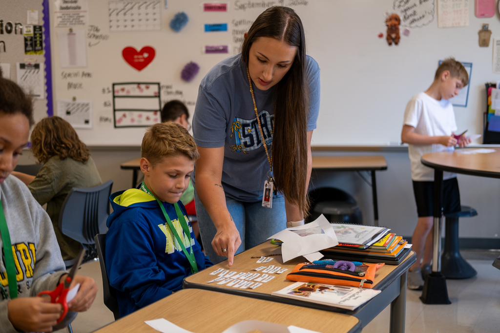 A teacher helps a student.