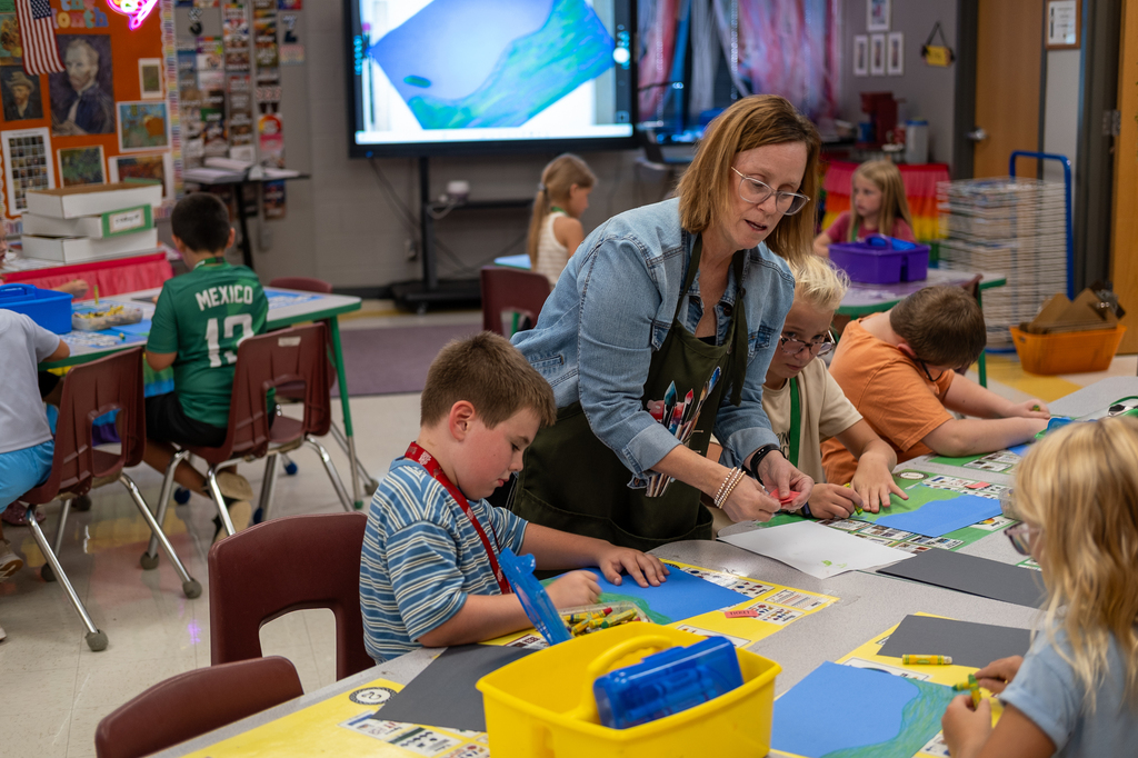 An art teacher assists students