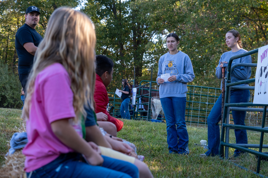 A high school ag student speaks with elementary students about dairy cows.