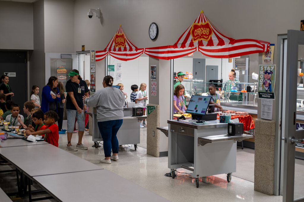 Staff serve lunch to students in a cafeteria
