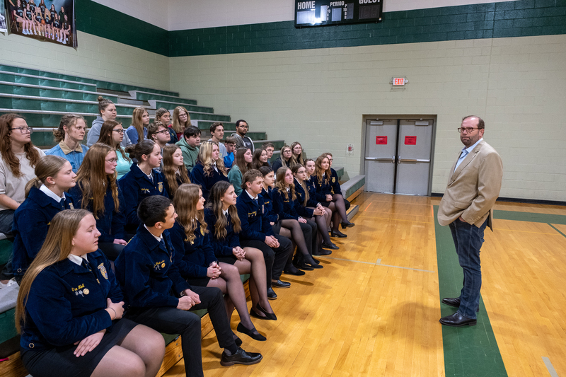 Rep. Jason smith speaks to a group of FFA students in the PCMS gymnasium. Many of the students are wearing their blue corduroy FFA jackets.