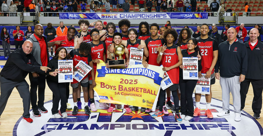 Some people holding banners and a trophy in a stadium
