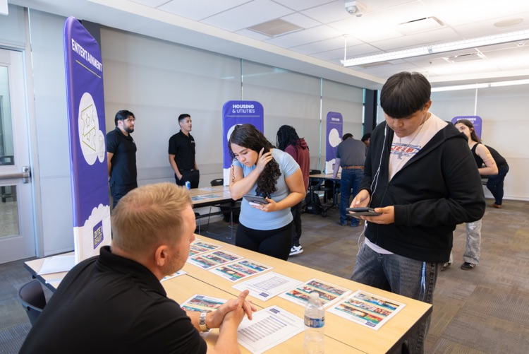 adult talking to two students at table