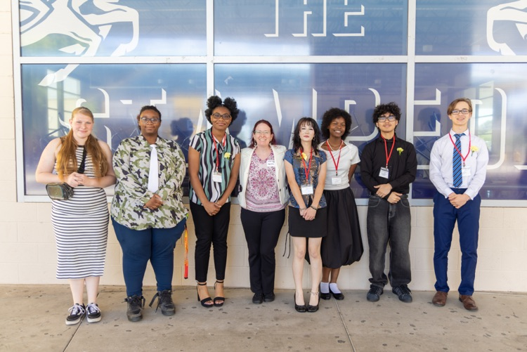 7 students and 1 teacher pose for a photo together