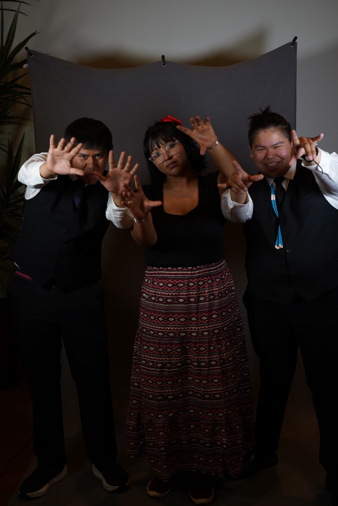 three students pose with hands up in cat-like way