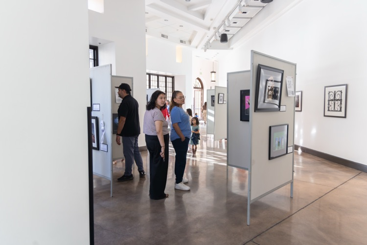 Crowd of people looking at student artwork