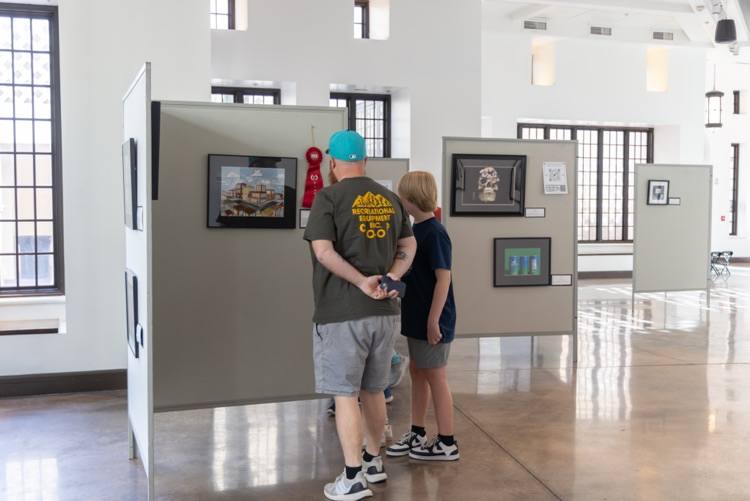 Crowd of people looking at student artwork