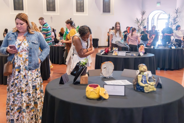 Crowd of people looking at student artwork