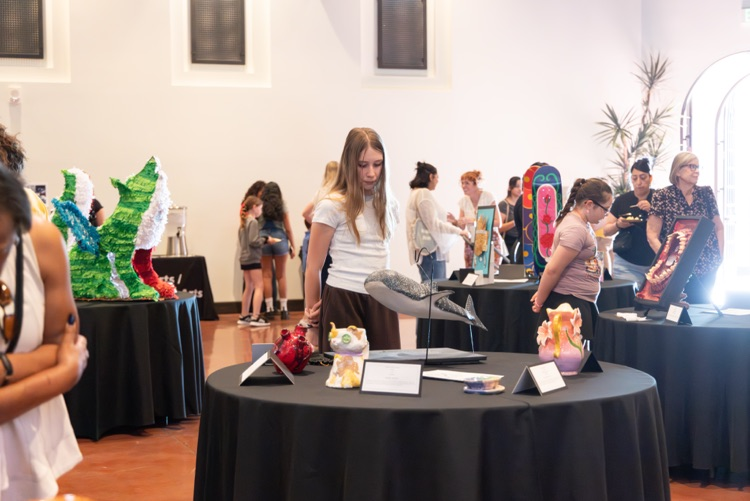 Crowd of people looking at student artwork