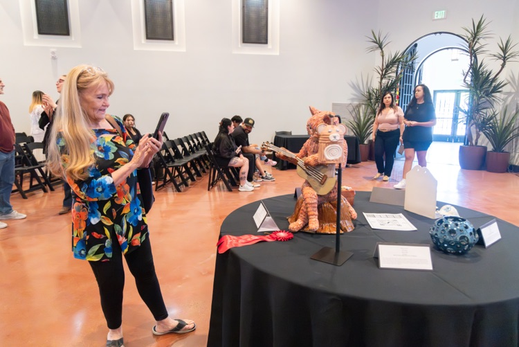 Crowd of people looking at student artwork