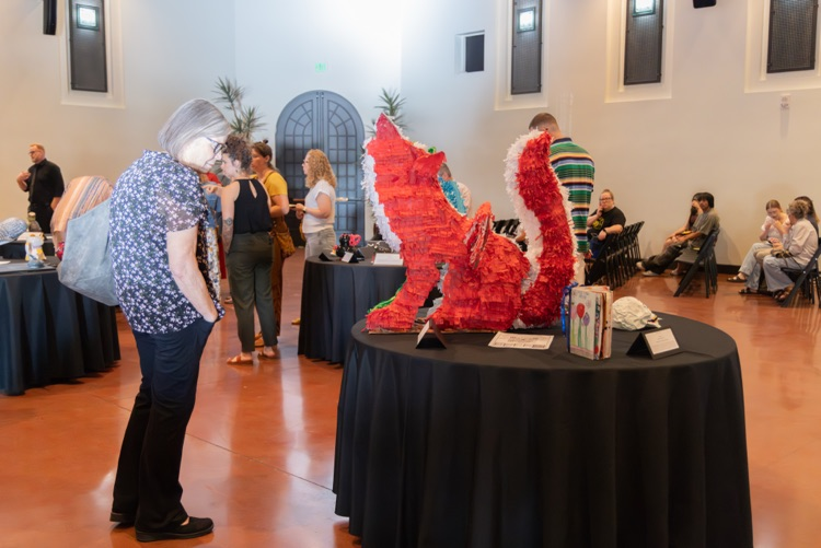Crowd of people looking at student artwork