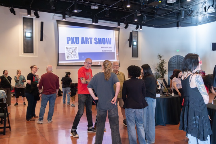Crowd of people looking at student artwork