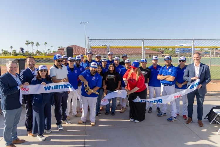 large group of people cutting a ribbon