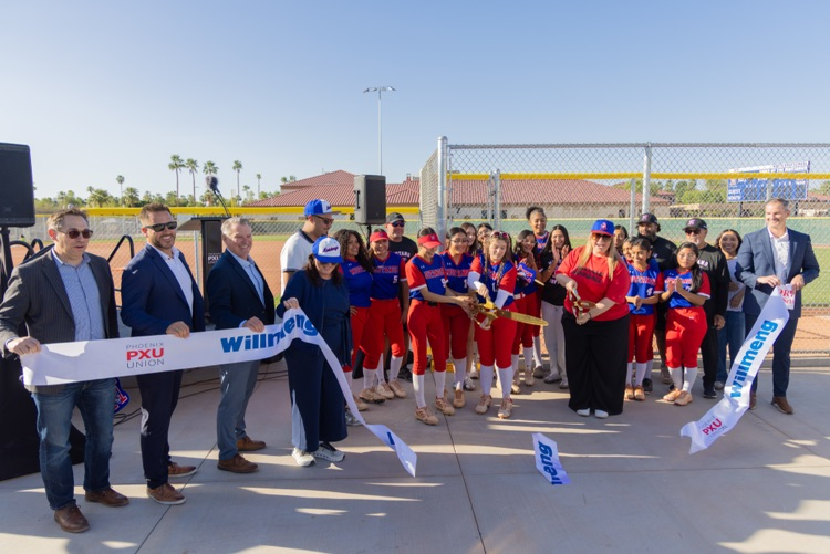 large group of people cutting a ribbon