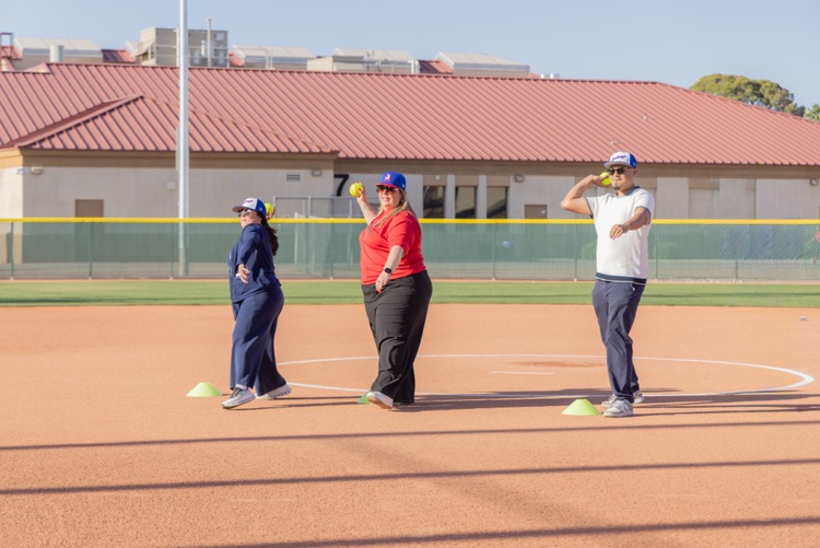 three people throw a softball