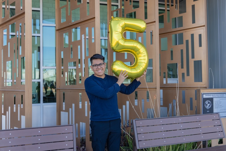 Joseph Parra Miguel holds a number 5 balloon