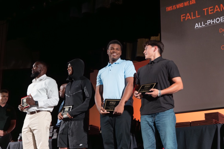students and coaches on stage at the All PXU sports awards