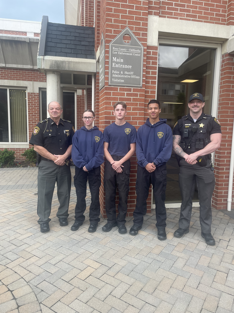 the Sheriff stands to the left of a group of students