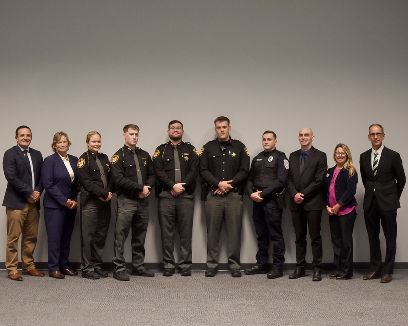 a group of law enforcement officials stand in a row