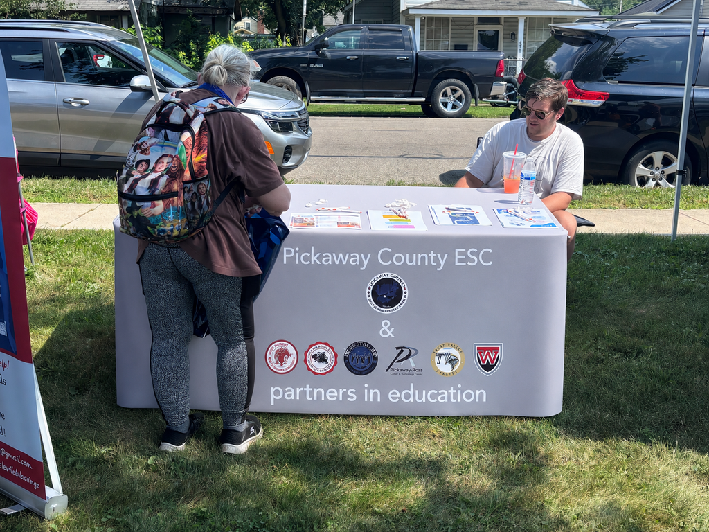 person standing out ESC table looking at information