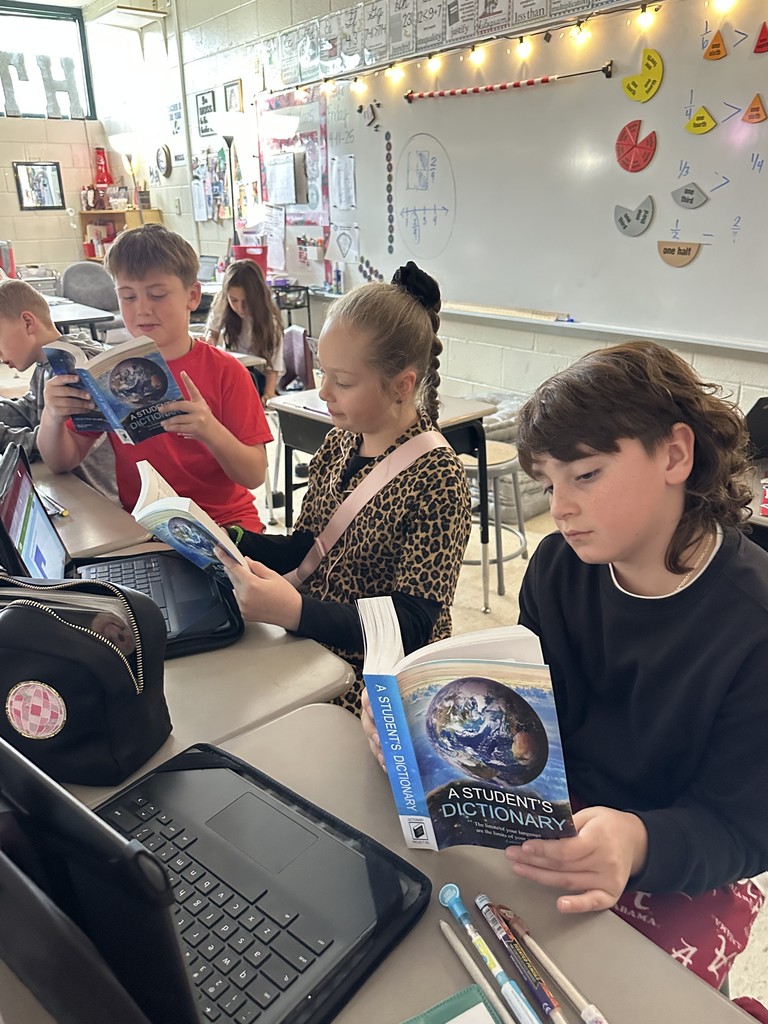 Third graders receive dictionaries.