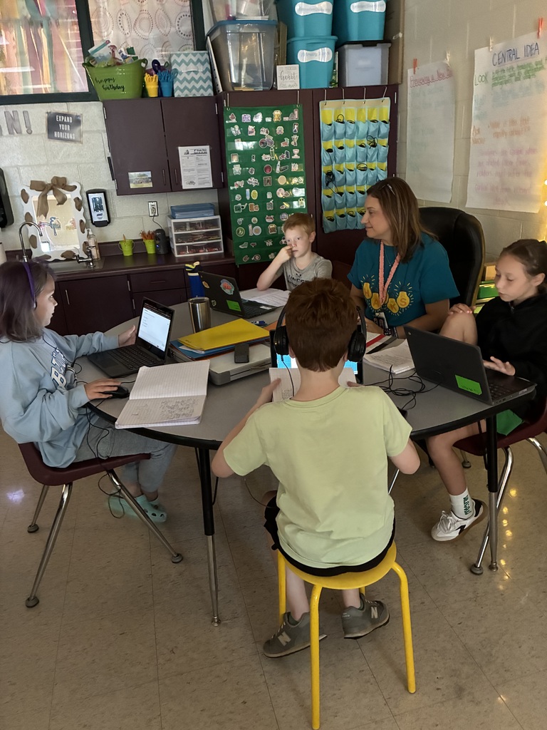 Students working with Mrs. Henson to write informative essays.