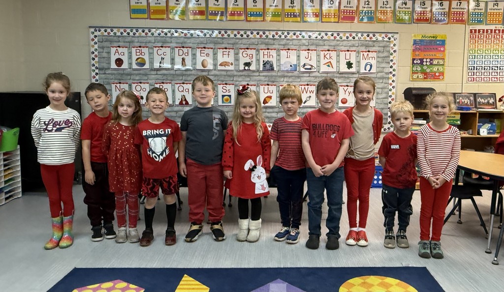 Group of kindergarten students standing at the from of their class  wearing red for red ribbon week