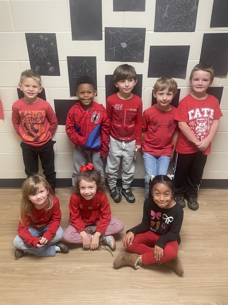 Group of kindergarten students standing the hallway of a school  wearing red for red ribbon week