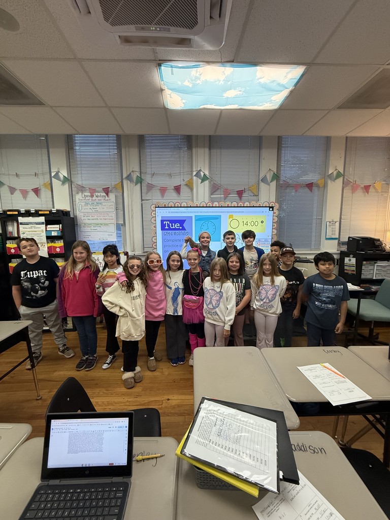 Group of fourth grade students standing in front of the classroom,  in decade clothes or dresses as celebrities for red ribbon week