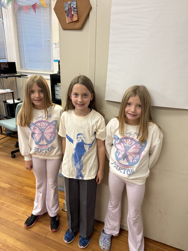 Three fourth grade students standing in front of the classroom dressed as celebrities for red ribbon week