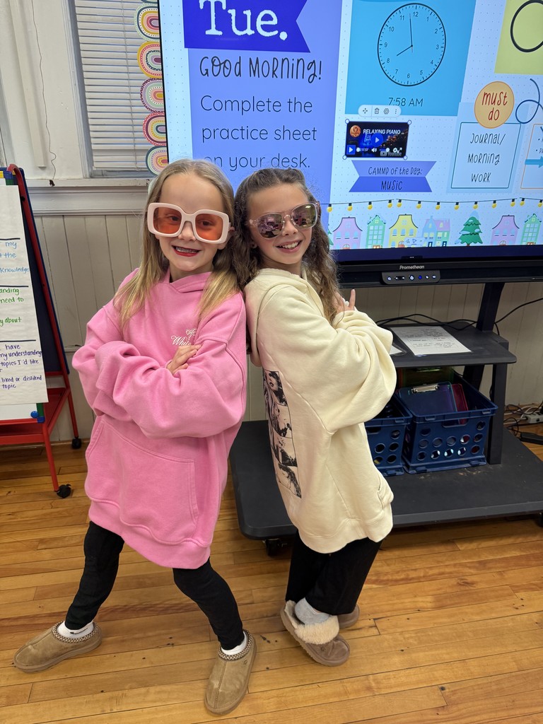 Two fourth grade students standing in front of the classroom  in decade clothes  for red ribbon week