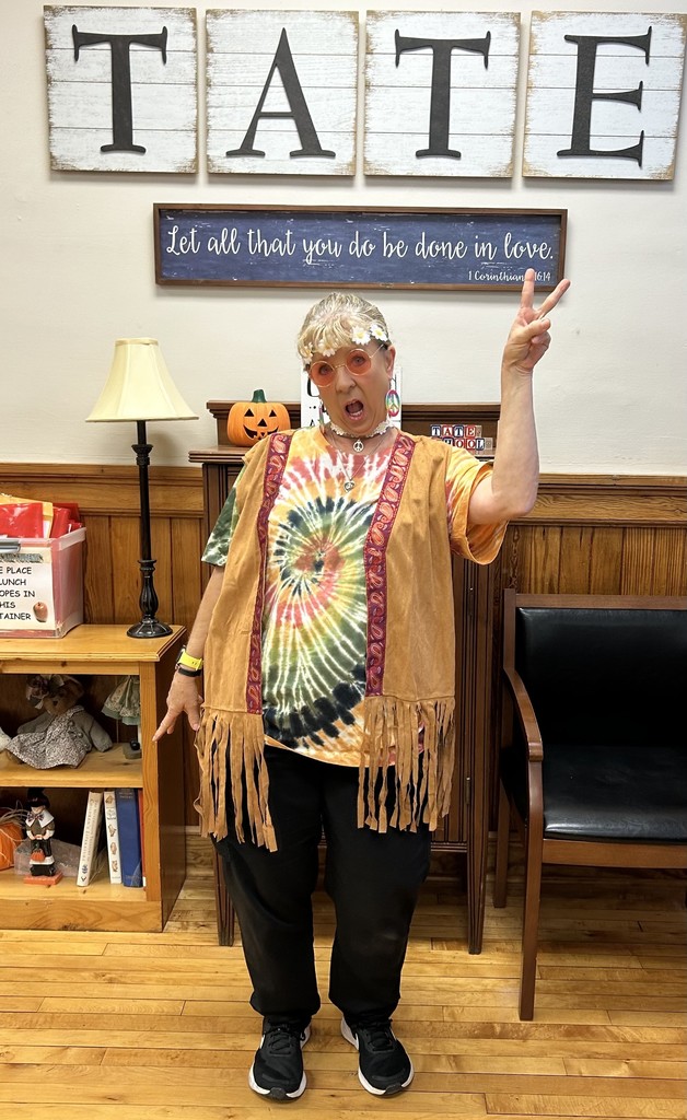 School Nurse  standing in front office dressed as a hippy for red ribbon week