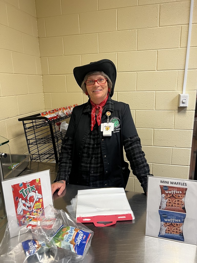 Gina Pyles, School Cafe Manager standing alone in the cafeteria dressed as a cowgirl to celebrate red ribbon week
