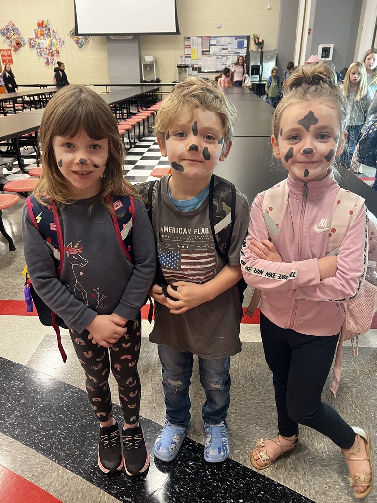 Three students standing in the cafeteria dressed as cows to celebrate red ribbon week