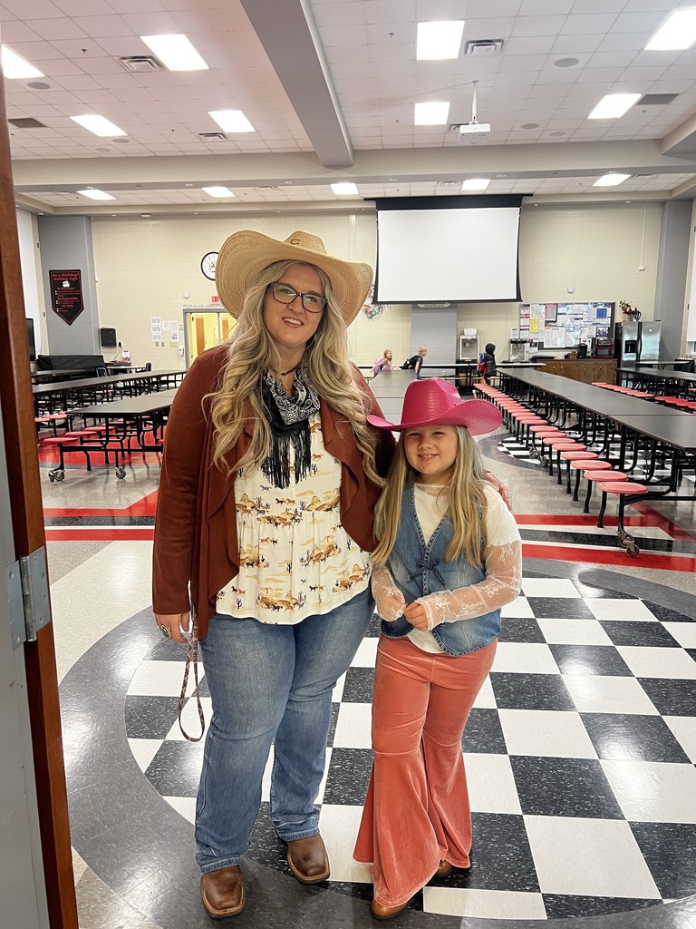 School Counselor and one girl student standing in the cafeteria dressed as cowgirls  to celebrate red ribbon week