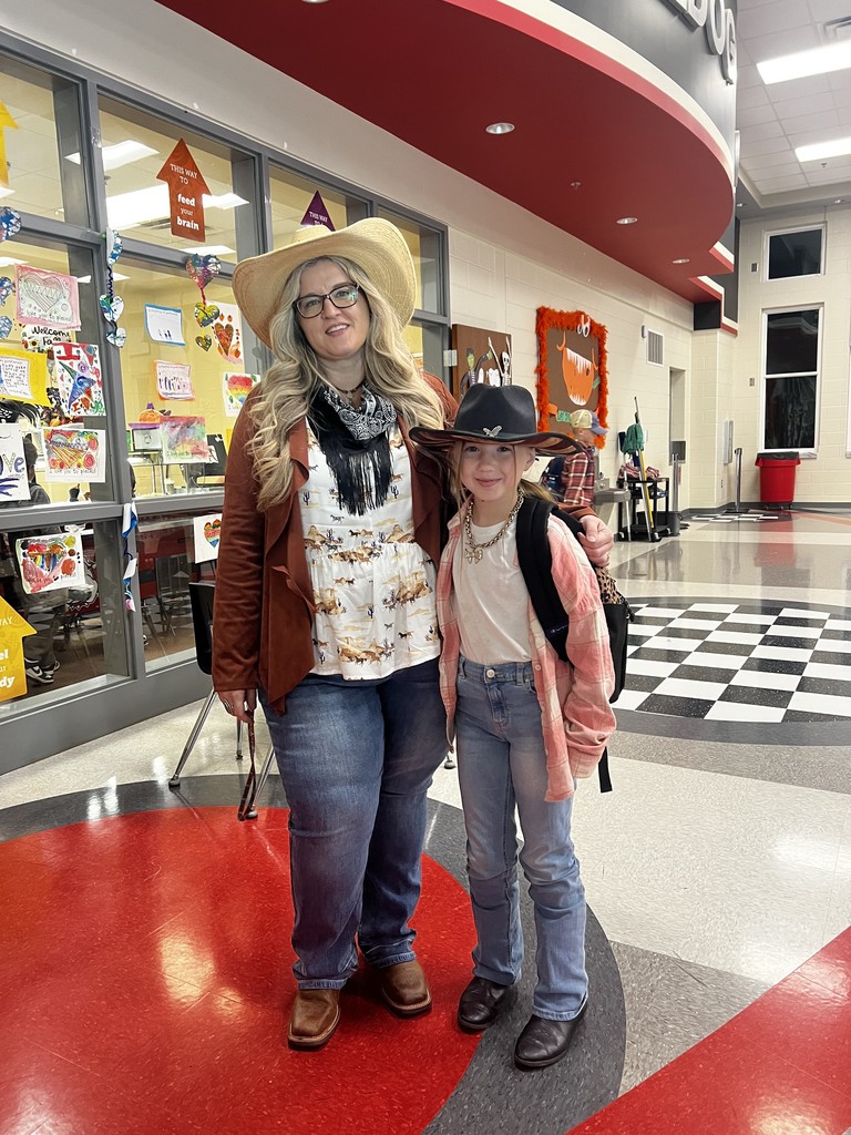 School Counselor and one female student standing in the cafeteria dressed as cowgirls  to celebrate red ribbon week