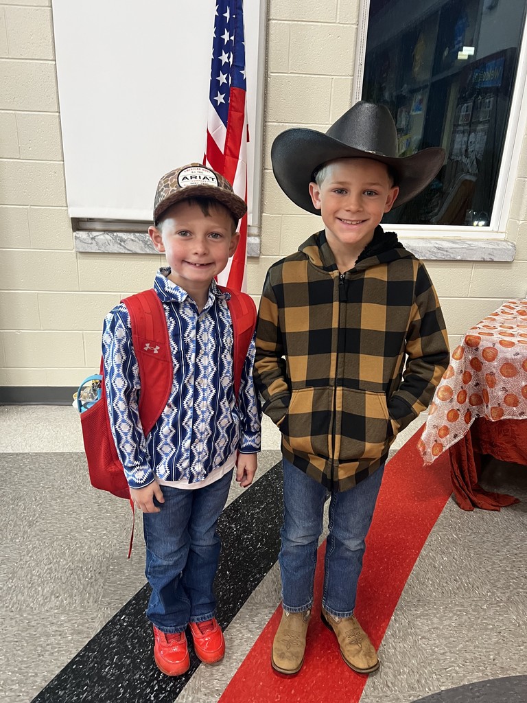 Two male students standing in the cafeteria dressed as cowboys to celebrate red ribbon week