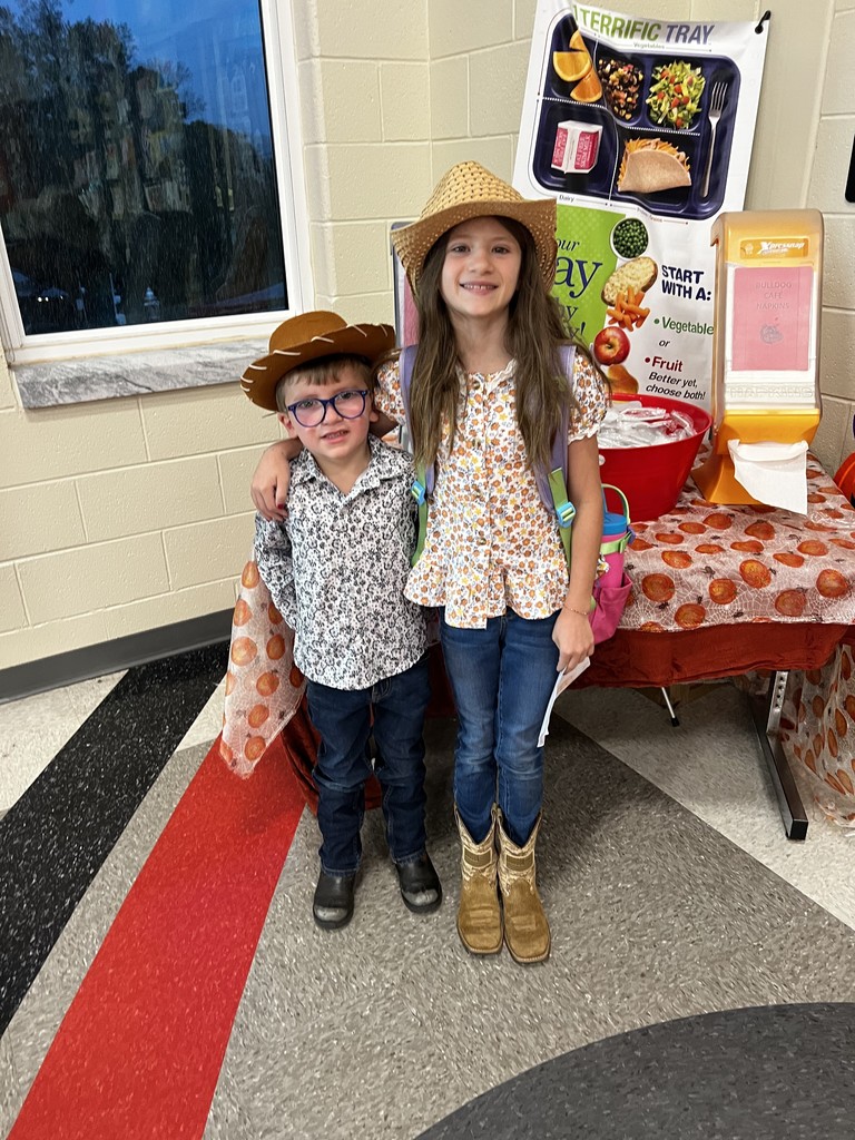 Two students standing in the cafeteria dressed as cowboys to celebrate red ribbon week