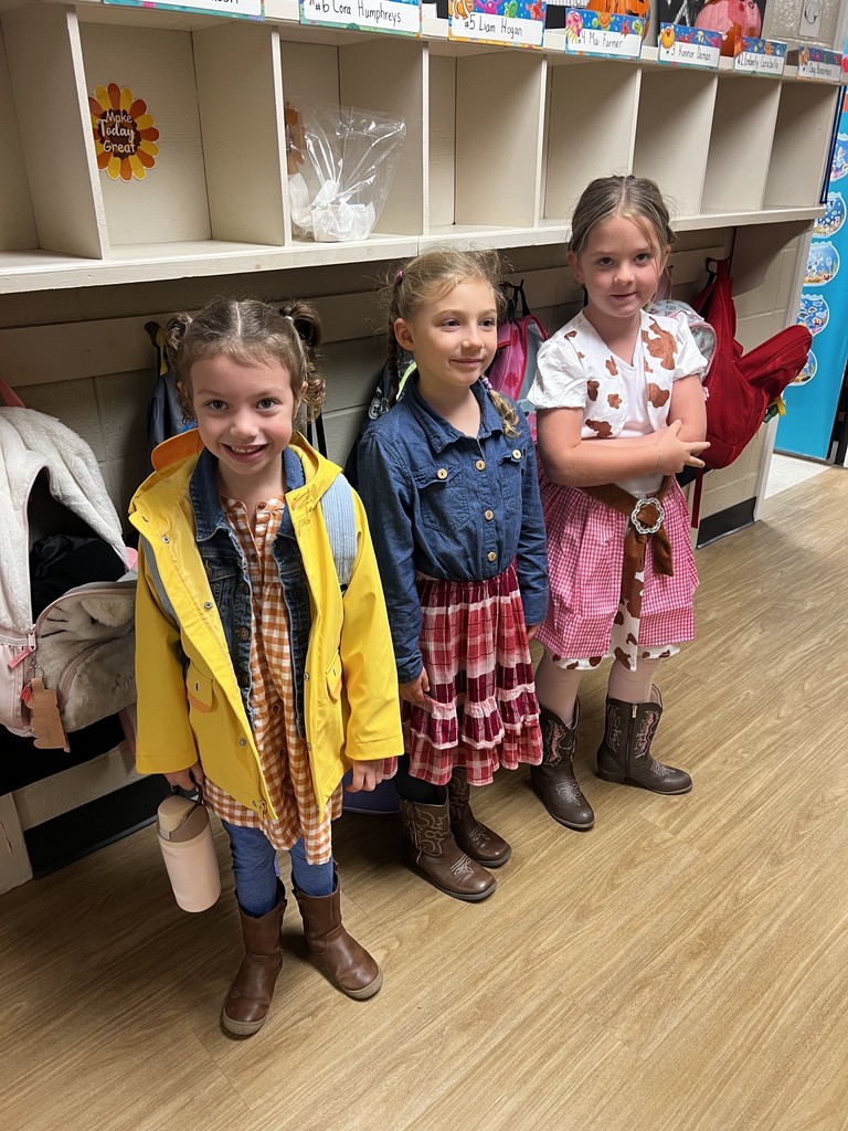 Three girl students standing in the hallway dressed as cowgirls to celebrate red ribbon week
