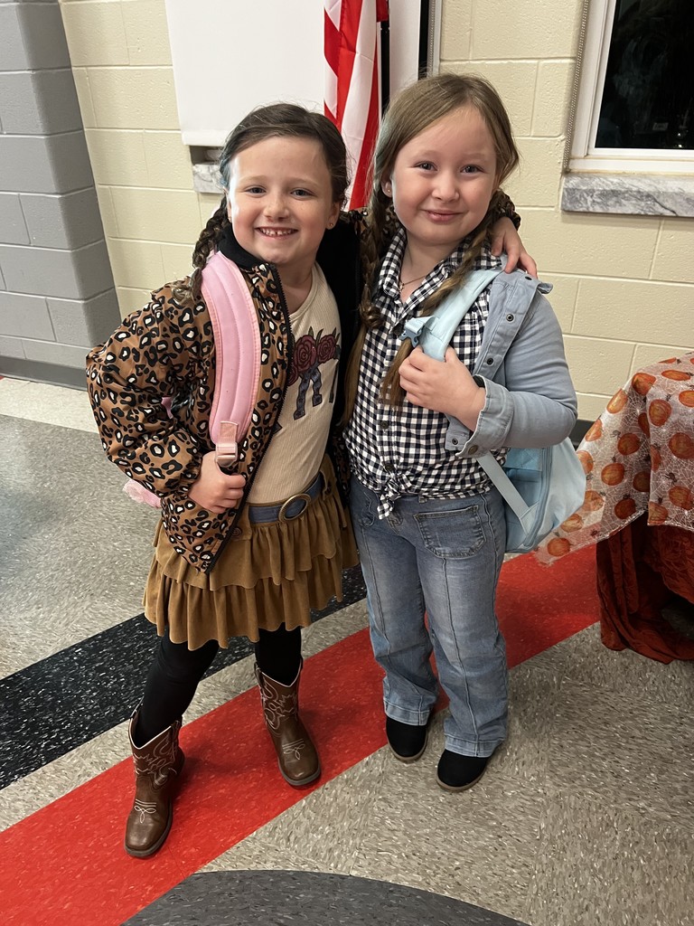 Two female students standing in the cafeteria dressed as cowgirls to celebrate red ribbon week