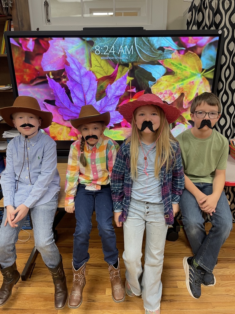 Group of students standing in front of the classroom wearing fake mustaches for red ribbon week